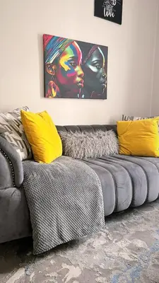 a gray couch with yellow pillows in a living room at Luxury on New in Midrand