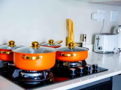 four pots on top of a stove in a kitchen at Luxury on New in Midrand