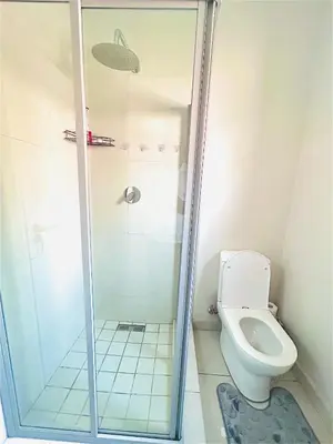 a bathroom with a shower and a toilet at Luxury on New in Midrand