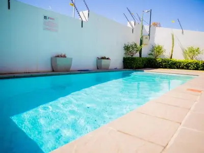 a large blue swimming pool in a building at Luxury on New in Midrand