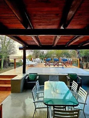 a patio with a table and chairs on a deck at Luxury GuesthouseCo RiverBend in Marloth Park