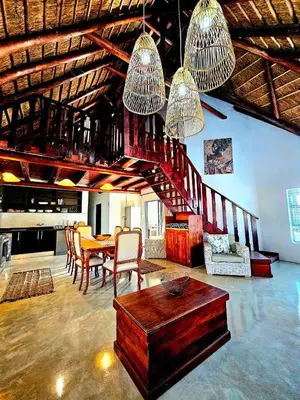a living room with a table and a dining room at Luxury GuesthouseCo RiverBend in Marloth Park