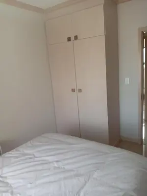 a white bedroom with a bed and two closets at Phoenix Living in Midrand