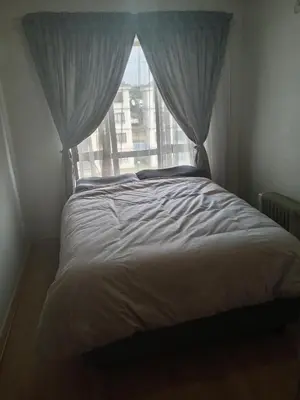 a bed in a bedroom with a window at Phoenix Living in Midrand