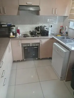 a small kitchen with a stove and a sink at Phoenix Living in Midrand