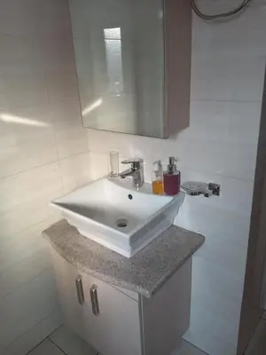 a bathroom with a white sink and a mirror at Phoenix Living in Midrand