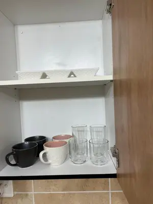 a kitchen shelf with bowls and glasses on it at Luxury Loft eMalahleni in Witbank