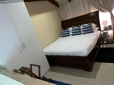 a bedroom with a bed with blue and white pillows at Luxury Loft eMalahleni in Witbank