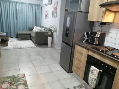 a kitchen and living room with a couch and a stove at Luna Luxury Living in Nelspruit