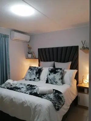 a bedroom with a large bed with white sheets and pillows at Luna Luxury Living in Nelspruit