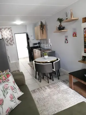 a living room with a table and a kitchen at Luna Luxury Living in Nelspruit