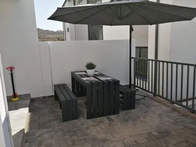 a patio with a table and an umbrella at Luna Luxury Living in Nelspruit