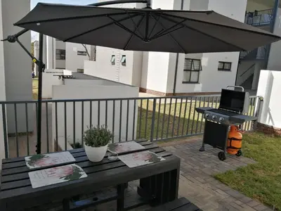 a black umbrella on a patio with a grill at Luna Luxury Living in Nelspruit