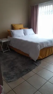 a bedroom with a large bed with a window at Home away from home in Polokwane
