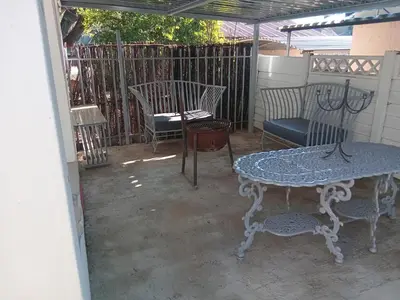 a patio with a table and chairs and a fence at Laetari Guest House in Hartbeespoort