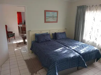 a bedroom with a bed with a blue comforter at Laetari Guest House in Hartbeespoort