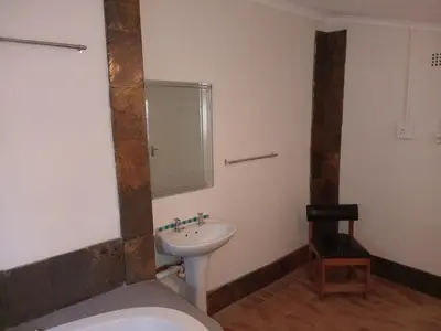 a bathroom with a sink and a toilet and a mirror at Laetari Guest House in Hartbeespoort