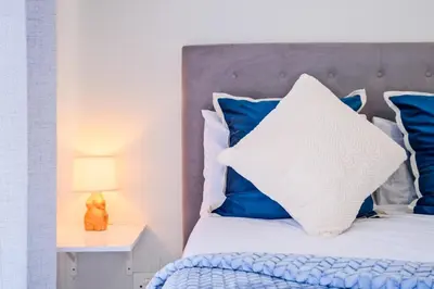 a bedroom with a bed with blue and white pillows at Navy Lagoon Stay The Blyde in Pretoria