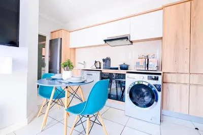 a kitchen with a washing machine and a table and chairs at Navy Lagoon Stay The Blyde in Pretoria