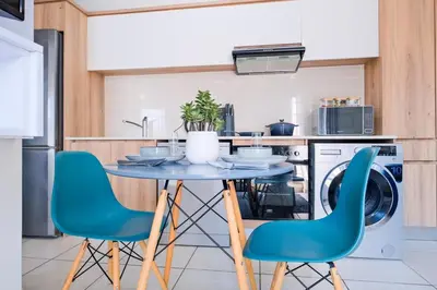 a kitchen with a blue table and chairs at Navy Lagoon Stay The Blyde in Pretoria