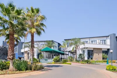 a street with palm trees in front of a building at Navy Lagoon Stay The Blyde in Pretoria