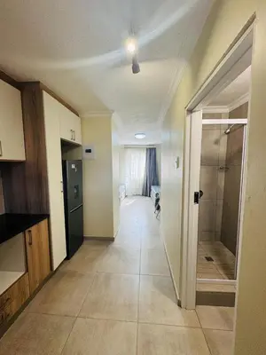 a room with a hallway with a walk in shower at Mhlahlo Guests in Ga-Rankuwa