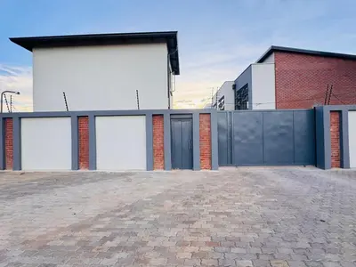 a house with four garage doors and a fence at Mhlahlo Guests in Ga-Rankuwa