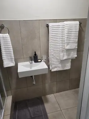 a bathroom with a sink and towels on the wall at Mhlahlo Guests in Ga-Rankuwa