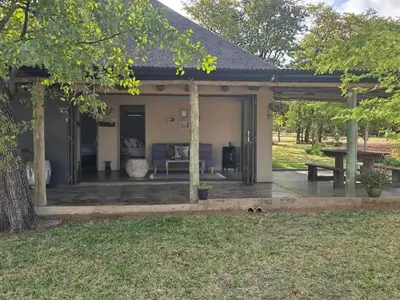 a pavilion with a picnic table and a bench at Tintshaba Safaris in Phalaborwa