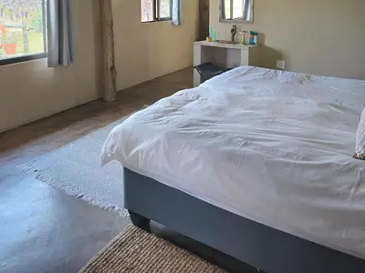 a bedroom with a large bed with white sheets at Tintshaba Safaris in Phalaborwa