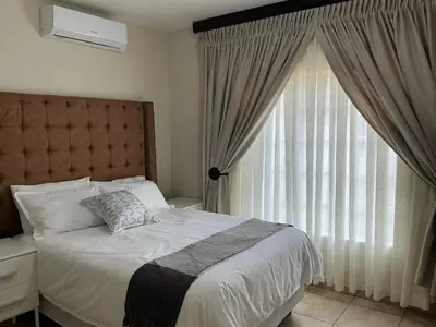 a bedroom with a bed and a large window at Luxstay in Nelspruit