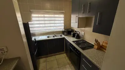 a small kitchen with a sink and a stove at Luxstay in Nelspruit