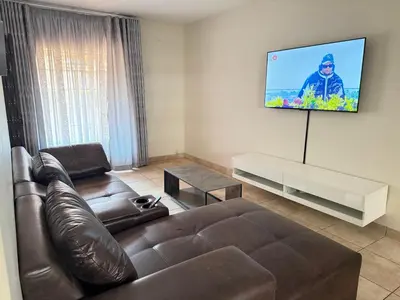 a living room with a couch and a flat screen tv at Luxstay in Nelspruit