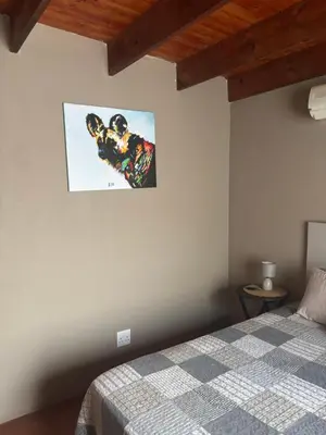 a bedroom with a bed and a picture on the wall at Kudu's Corner in Marloth Park