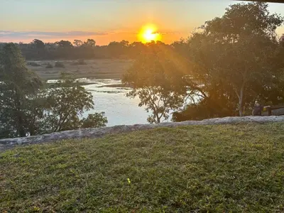 a sunset over a river with the sun setting at Kudu's Corner in Marloth Park