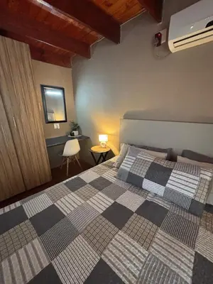 a bedroom with a bed with a checkered blanket at Kudu's Corner in Marloth Park