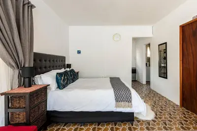 a bedroom with a large bed with white sheets at Private Garden Home Fast WiFi in Centurion