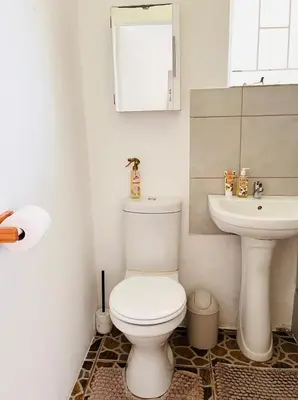 a bathroom with a white toilet and a sink at Private Garden Home Fast WiFi in Centurion
