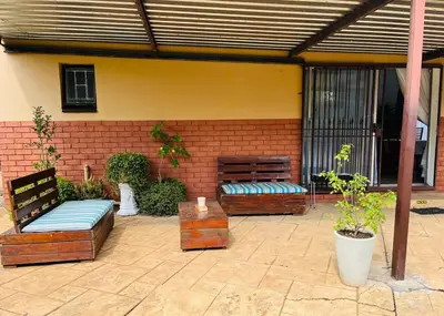 a patio with two benches and a brick wall at Private Garden Home Fast WiFi in Centurion