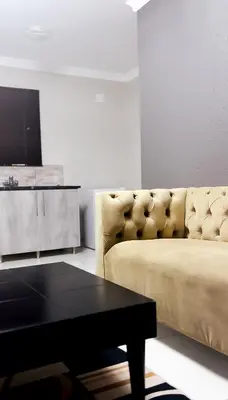 a living room with a couch and a coffee table at Nyakhosi Luxury Guesthouse in Thohoyandou