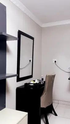 a desk with a mirror and a chair in a room at Nyakhosi Luxury Guesthouse in Thohoyandou