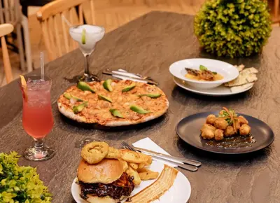a table with plates of food and a drink at Blyde Lagoon in Pretoria