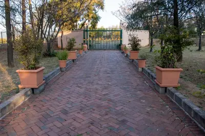 a brick walkway with potted plants on it at The Glenwood RRR Guesthouse in Midrand
