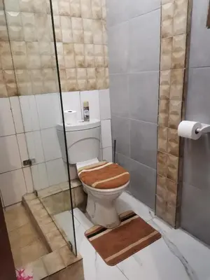 a toilet with a wooden seat in a bathroom at The Glenwood RRR Guesthouse in Midrand