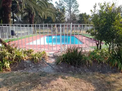 a swimming pool with a fence around it at The Glenwood RRR Guesthouse in Midrand