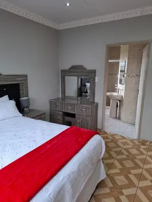 a bedroom with a bed and a sink and a mirror at Entire Modern House!!- Middelburg in Middelburg