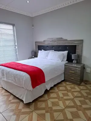a bedroom with a large bed with a red blanket at Entire Modern House!!- Middelburg in Middelburg