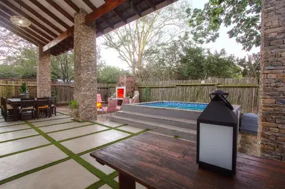 a patio with a table and a swimming pool at Edjami River View in Marloth Park