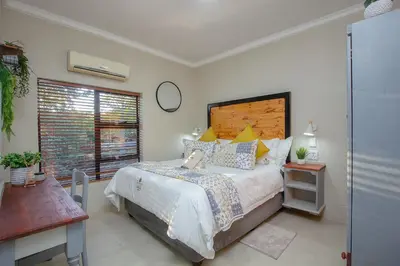 a bedroom with a large bed and a window at Edjami River View in Marloth Park