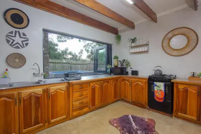 a large kitchen with wooden cabinets and a window at Edjami River View in Marloth Park